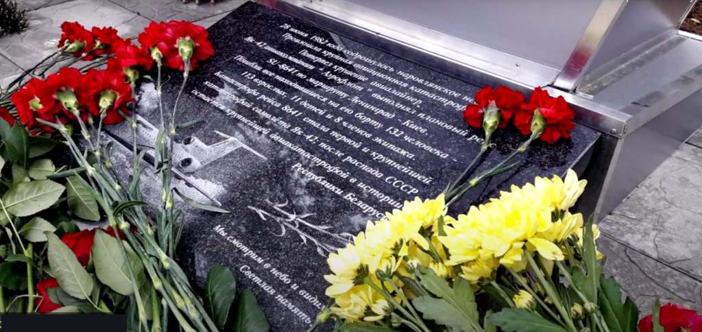 Пам'ятна плита з квітами, яка вшановує пам'ять жертв історичних подій.