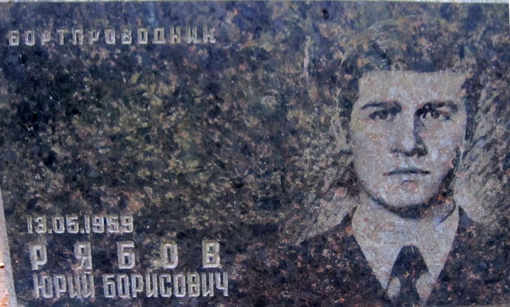 Меморіальна плита з зображенням чоловіка на фоні та текстом, що містить ім'я, прізвище та дату народження.
